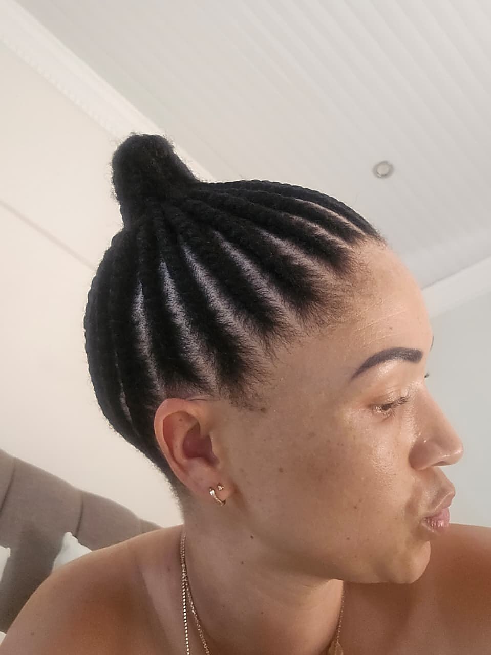 Sleek cornrow bun side profile